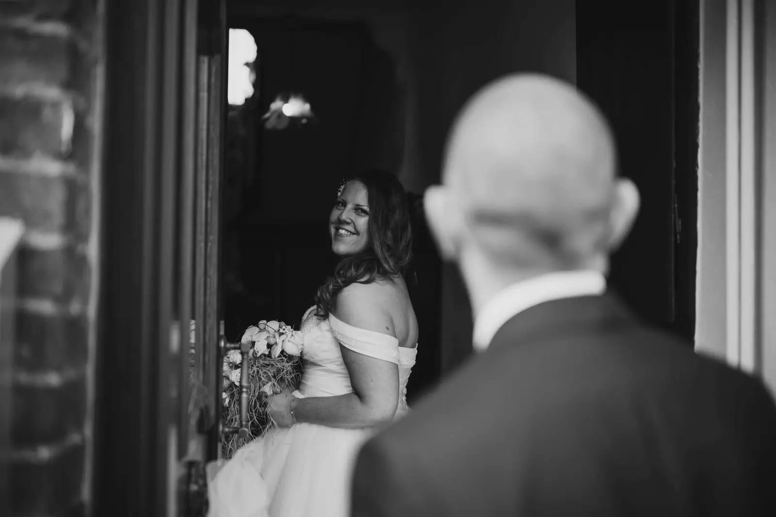 La mariée se retourne vers le marié dans une photographie en noir et blanc