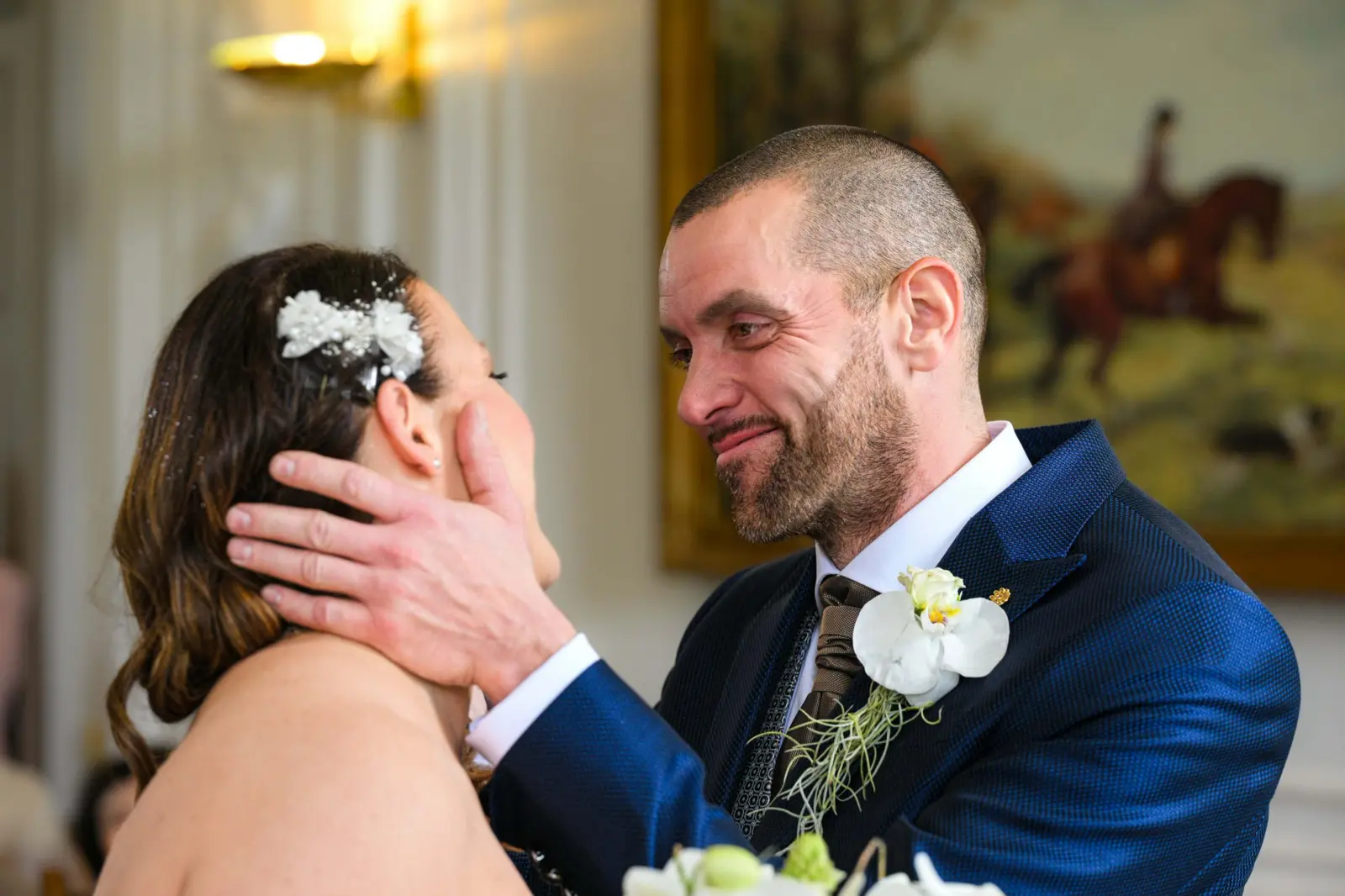 Le marié pose tendrement la main sur le visage de la mariée