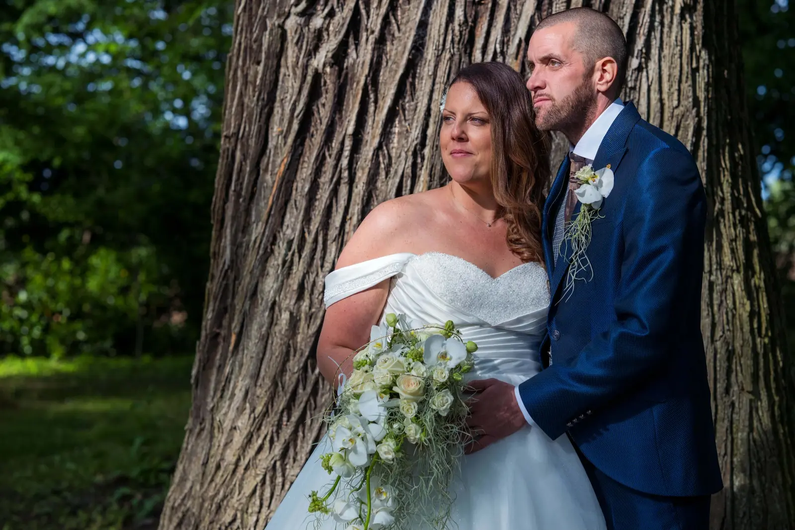 Portrait des mariés devant le tronc d’un grand arbre